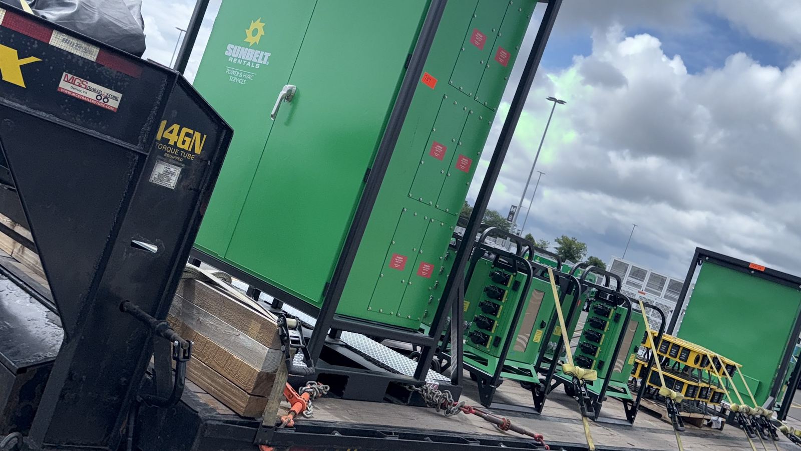 Rental power equipment chained down on a gooseneck trailer